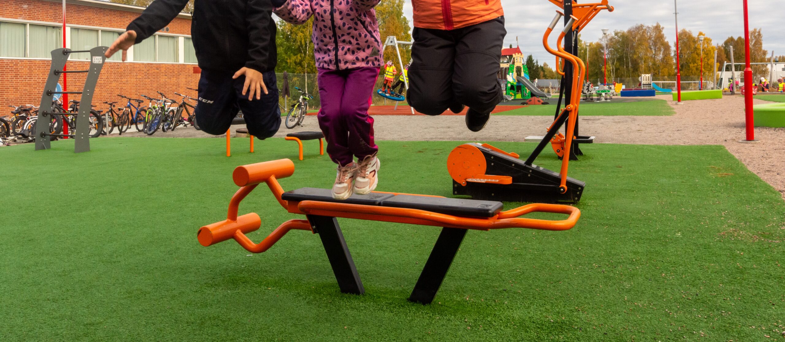 Lapset hyppäävät koulun pihalla